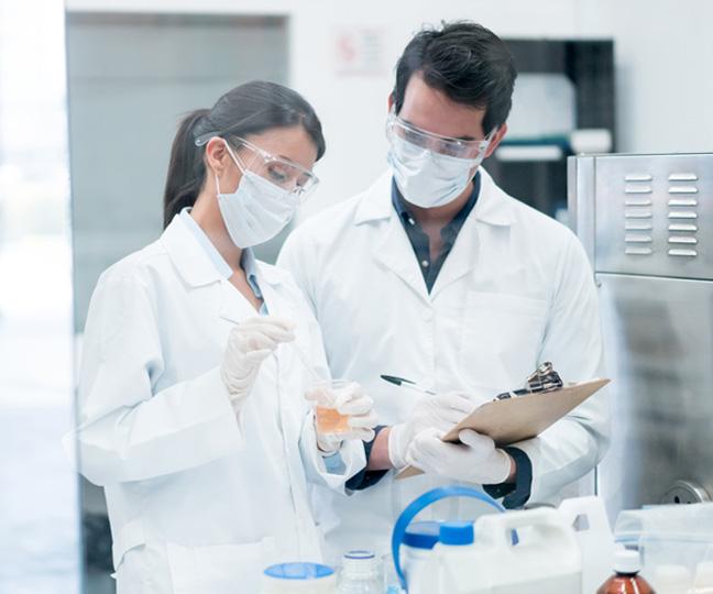 Zwei Chemiker, die im Labor Produkte in Reagenzgläsern mischen