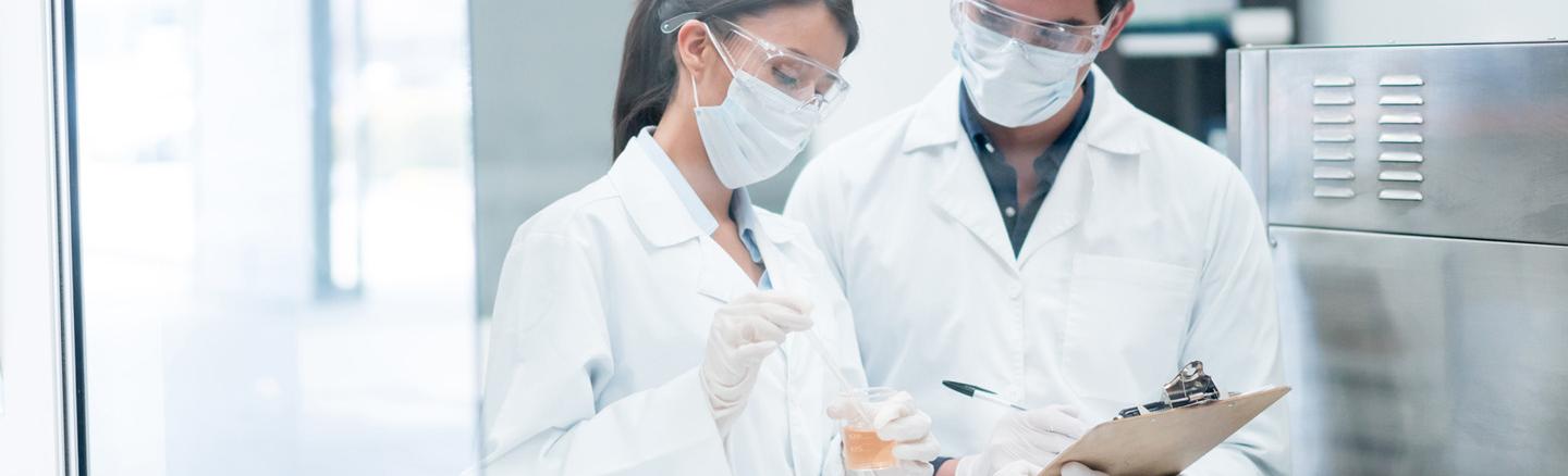 Zwei Chemiker, die im Labor Produkte in Reagenzgläsern mischen